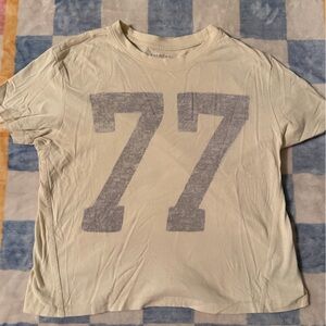 American Eagle Outfitters Cream T‑Shirt with Faded Blue '77' Graphic